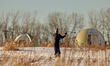 A young female skis in Frederic Back Park near the biogas spherical valves in Montreal, Ca...