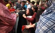 People crowd in long queues to purchase subsidized essentials from trucks operated by the...