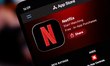 The Netflix logo appears on a smartphone screen in the Apple app store in this photo illus...