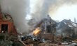 A fire rages in a house destroyed by a Russian attack in Sofiivska Borshchahivka village,...