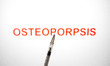 The word OSTEOPOROSIS appears on a computer screen with a medical syringe in this photo il...