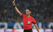 The referee of the match, Jose Maria Sanchez from Spain, shows the yellow card during the...