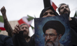 A veiled Iranian woman holds a portrait of Iran's Supreme Leader, Ayatollah Ali Khamenei d...