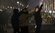 Protesters raise two fingers as a police water cannon sprays in the Ish-Blloku area of Tir...