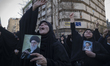 Veiled Iranian women hold portraits of Iran's Supreme Leader Ayatollah Ali Khamenei and mo...