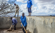Workers of the Mubuyu Farm coffee factory in Zambia rake coffee in water to remove red ski...