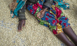 A woman sorts out the beans of coffee on the drying floor at the Mubuyu Farm coffee factor...