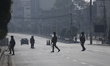 Security personnel check vehicles on an otherwise empty road in the Kathmandu Valley durin...