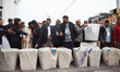 Election officials carry a sealed ballot box to transport it to a vote counting center aft...