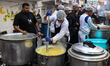 Egyptians gather for a communal iftar, the fast-breaking evening meal, during the 12th com...