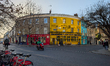 Colorful corner buildings, including the Sun in Splendour pub, stand at the junction with...