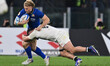 Louis Lynagh of Italy and Ben Earl of England are tackled during the Guinness Six Nations...