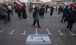 A female supporter of Iran's Late Leader Ayatollah Ali Khamenei walks past an Israeli flag...