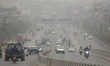 A general view shows vehicles moving along a roadside under polluted haze in Kathmandu, Ne...