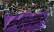 Dozens of activists march and give speeches while carrying posters during the Internationa...