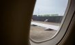The apron at Katowice Airport is visible through an aircraft window, with the Welcome to K...