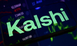 Kalshi's logo is displayed on a smartphone placed on a reflective surface onto which a sto...