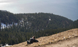 A hiker couple rests and views the mountain panorama on Jochberg summit near Jachenau, Bav...