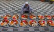 A Muslim devotee arranges plates of food ahead of iftar time at a mosque in Kolkata, India...