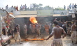 A devotee fire eater performs stunts and a traditional dance before devotees carry idols o...