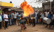 A devotee fire eater performs stunts and a traditional dance before devotees carry idols o...