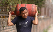 A Nepali consumer carries empty LPG cylinders as they rush to gas depots to refill them as...