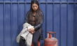 A Nepali consumer waits in line carrying empty LPG cylinders as they rush to gas depots to...