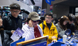 Fairgoers are seen at the Qianwen AI glasses booth at the SNEIC expo center in Shanghai, C...