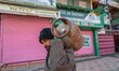 A Kashmiri man carries an empty liquefied petroleum gas (LPG) cylinder on his shoulder alo...