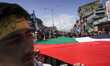Kashmiri Shia Muslims wave the Palestinian flag and shout slogans against the US and Israe...