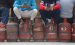 Nepali consumers queue to receive partially filled Liquefied Petroleum Gas (LPG) cylinders...