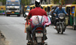 A person carries an LPG gas cylinder on a motorcycle during an LPG supply issue in Kolkata...