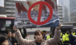 A university student holds a large protest sign during a press conference at Gwanghwamun P...