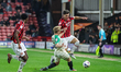 Liam Bennett of Cambridge United challenges Mason Hancock of Walsall FC during the Sky Bet...