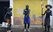 Residents wearing masks and with painted bodies, known as 'Xinacates,' walk the streets of...