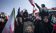 A veiled Iranian woman mourns as she holds a portrait of Gholamreza Soleimani, commander o...