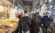 An Iranian couple walk through the traditional bazaar during New Year shopping in northern...