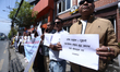 Activists from the Human Rights and Peace Society hold placards during a protest calling f...