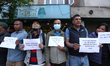 Activists from the Human Rights and Peace Society hold placards during a protest calling f...