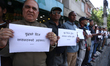 Activists from the Human Rights and Peace Society hold placards during a protest calling f...