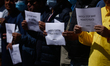 Activists from the Human Rights and Peace Society hold placards during a protest calling f...