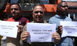 Activists from the Human Rights and Peace Society hold placards during a protest calling f...
