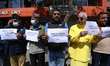 Activists from the Human Rights and Peace Society hold placards during a protest calling f...