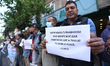 Activists from the Human Rights and Peace Society hold placards during a protest calling f...