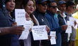 Activists from the Human Rights and Peace Society hold placards during a protest calling f...
