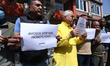 Activists from the Human Rights and Peace Society hold placards during a protest calling f...