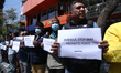 Activists from the Human Rights and Peace Society hold placards during a protest calling f...