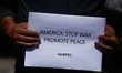 Activists from the Human Rights and Peace Society hold placards during a protest calling f...