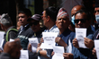 Activists from the Human Rights and Peace Society hold placards during a protest calling f...