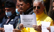 Activists from the Human Rights and Peace Society hold placards during a protest calling f...